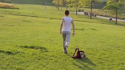 A guy running along the grass, rejoicing and having fun Video stock 79096124