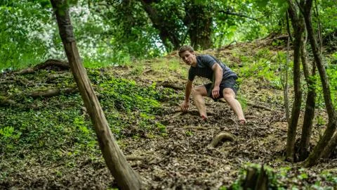 The guy is running down a steep hill while participating in an ocr race Stock Photos
