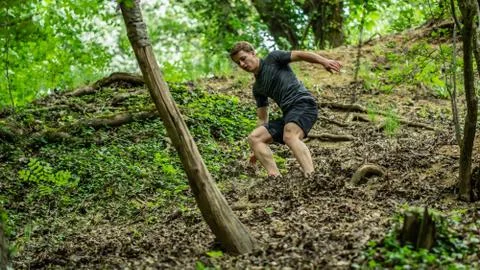 The guy is running down a steep hill while participating in an ocr race Stock Photos