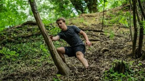 The guy is running down a steep hill while participating in an ocr race Stock Photos