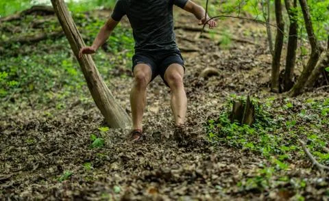 The guy is running down a steep hill while participating in an ocr race Stock Photos