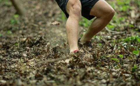 The guy is running down a steep hill while participating in an ocr race Stock Photos
