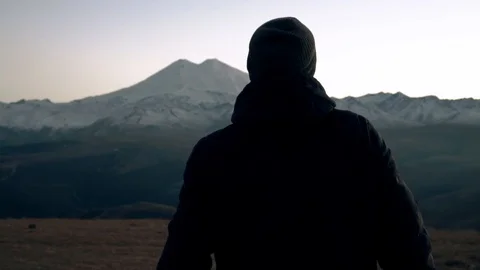 Guy runs across the field in the mountains Stock Footage 98450686