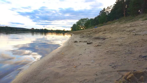 The guy runs along the sandy beach of the lake Stock Footage 93844660