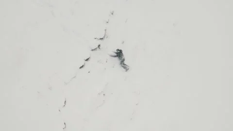 The guy runs and rolls down a cliff in the snow. Aerial photography. Stock Footage 295831178