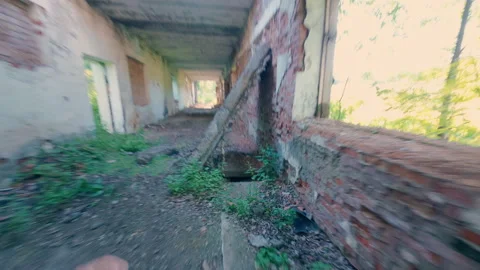A guy runs down the corridor of an abandoned building from danger. Stock Footage 313359455