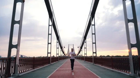Guy runs on a foot bridge in the city Stock Footage 117541534