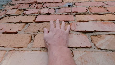 The guy runs his hand vertically along the brick wall. From the first person. 스톡 동영상 342422216