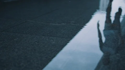 Guy runs on a puddle closeup Stock Footage 117546846