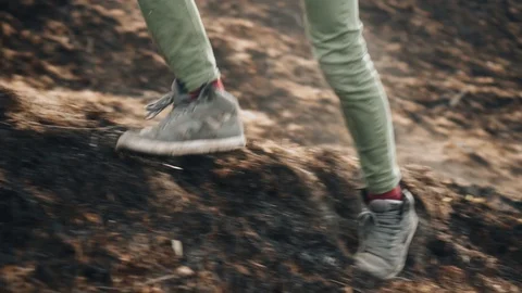 The guy runs through the burned grass. Ash and dust fly from under your feet Stock Footage 128016544