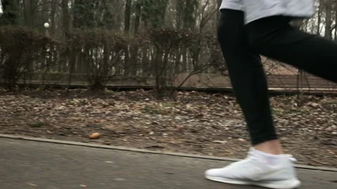 A guy runs through the park, a close-up of his legs, a man does sports Stock Footage 237989112