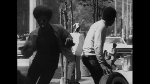 Guy runs through the urban ghetto as people watch him - 1969 Stock Footage 94256079