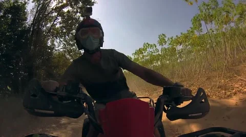 The guy rushes through the Thai jungle and the sand on the ATV quad bike Stock Footage 63114002