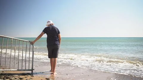 The guy is sad at the edge of the beach. he was thinking about something Stock Photos