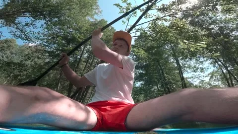 The guy is sailing on a SUP board and the camera looks at his face as he rows an Stock Footage 278508400