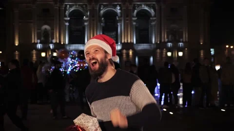Guy in Santa hat with Christmas present have positive emotions Christmas. Video stock 142234569