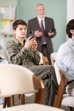 Guy scans a barcode during a lecture in front of a teacher Stock Photos