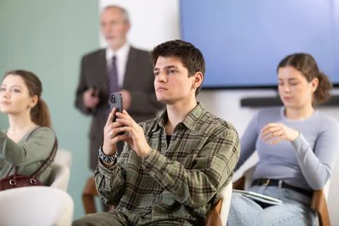 Guy scans a barcode during a lecture in front of a teacher Stock Photos