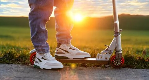 Guy on a scooter and at sunset Stock Photos