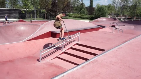 Guy on scooter doing tricks in skate park Video stock 102249142