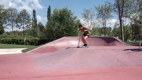 Guy on scooter jumping in park and stops Video stock 102249089
