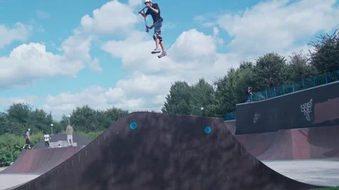 Guy on a scooter performs a trick at the skate park Stock-Footage 345906871