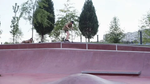 Guy on the scooter slides on the railing and jumps off them Stock-Footage 102248650