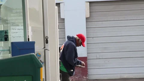 Guy scratching off lottery ticket outside gas station Stock Footage 155386813
