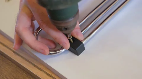 The guy is screwing a self-tapping screw with a screwdriver. Screwing a self Stock Footage 220803336