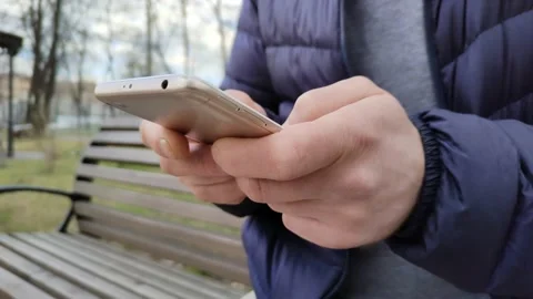 The guy scrolls through the news feed on his smartphone. Modern information 스톡 동영상 238926488