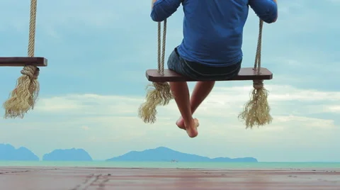 The guy at the sea going on the swings Stock Footage 64215248