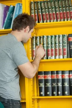 Guy searching a book 스톡 사진