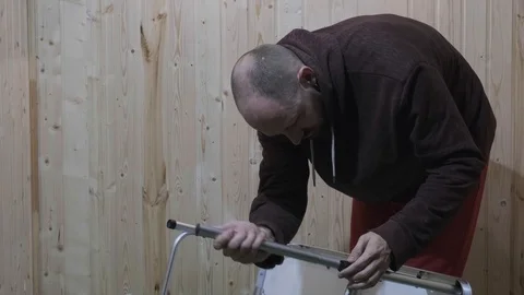 The guy sets the legs on a folding table Stockbeeldmateriaal 119554383