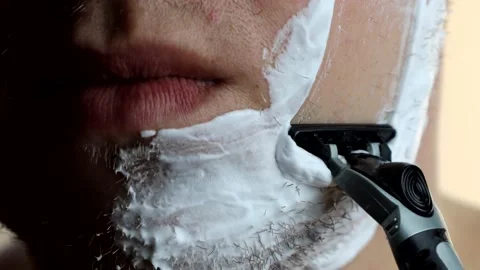 The guy shaves one side of his face. Hygiene facial care. High quality 4k footag Stock Footage 172125183