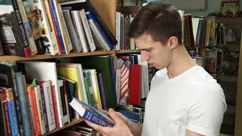 Guy at the shelves with books 스톡 동영상 155962848
