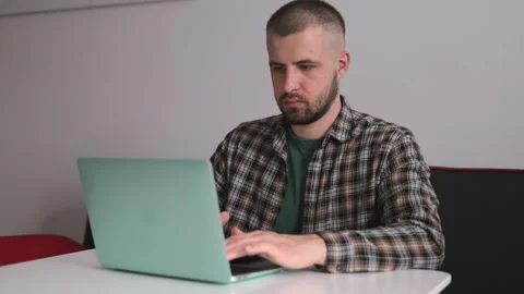 The guy in the shirt is working on the computer, working remotely. Freelancer Video stock 190020854