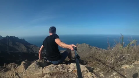 The guy shoots himself on the edge of a cliff Stock Footage 196136122