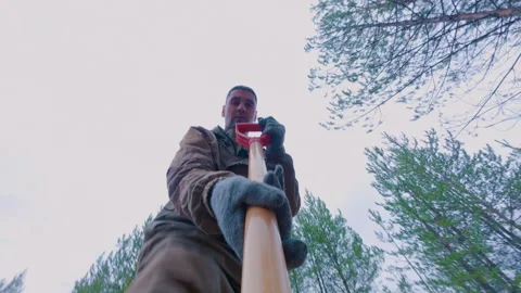 A guy with a shovel is digging a hole in the woods. A man digs up the ground. Stock Footage 319338979