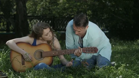The guy shows the girl how to play the guitar 動画素材 80809695
