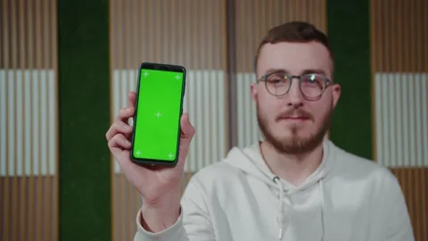 The guy shows the phone in a vertical position with green screen chroma key Stock Footage 194162771