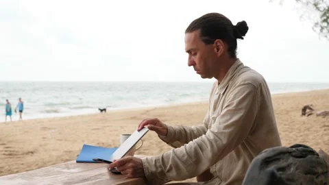 Guy shut down laptop and start using phone, freelancer sit against sea beach Stock Footage 147159769