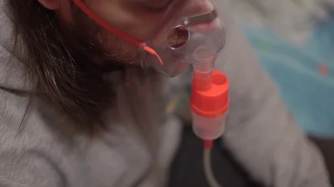 Guy is sick, does medical procedures, therapeutic inhalation, watches in Stock Footage 122136944