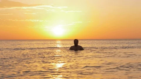 Guy silhouette dives in boundless ocean in summer morning Stock Footage 124024257