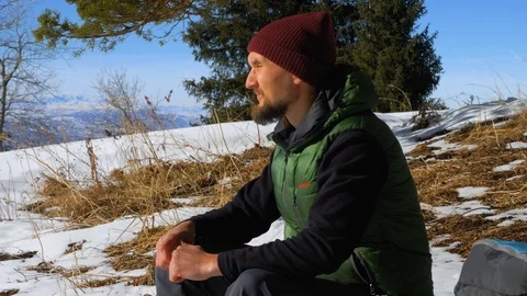 The guy sits on a bench in the mountains. He is resting Vídeos de archivo 104173828