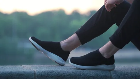 Guy sits in black sneakers Stock Footage 117543917