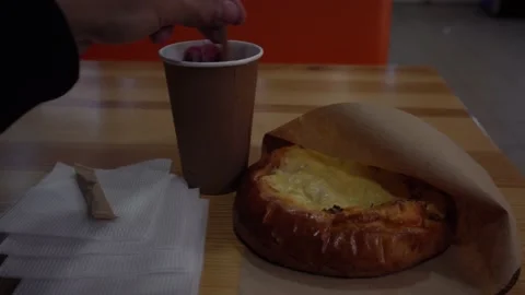 Guy sits in a cafe eating a small pizza and drinking fruit tea Stock Footage 139689314