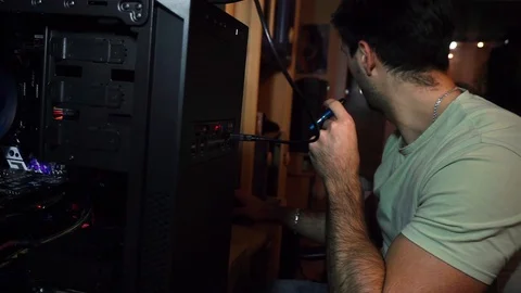 The guy sits at a disassembled system unit, a computer, works and soars Stock Footage 121479761