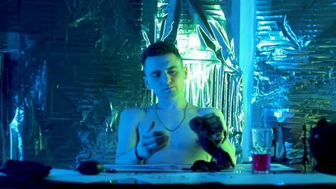 The guy sits down at the table and puts on black gloves Vidéo 123573434