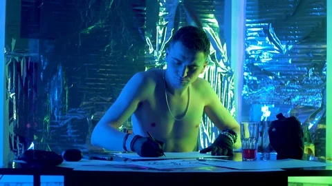 The guy sits down at the table and draws a sketch of the picture. Видео 123573592