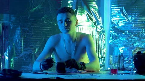 The guy sits down at the table and puts headphones in his ears Vidéo 123573739